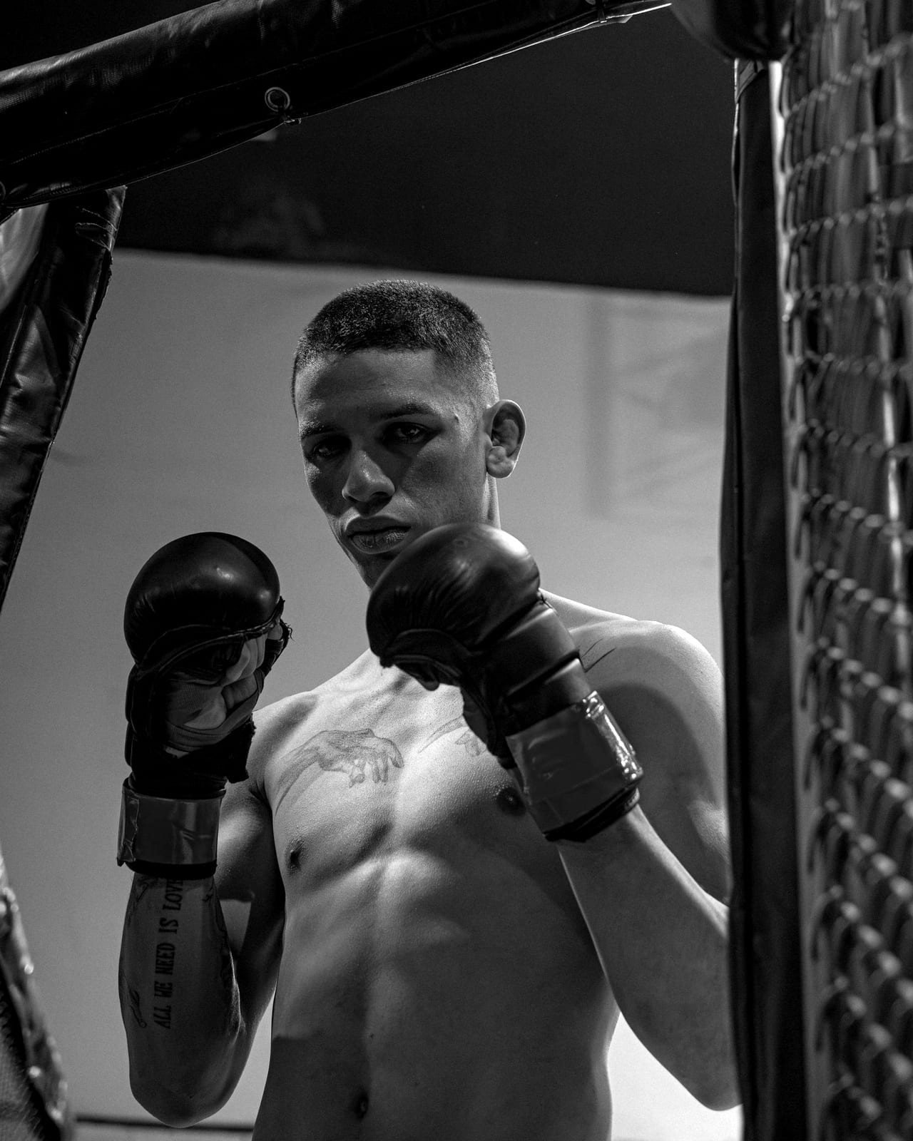 A fighter in boxing gloves inside a cage